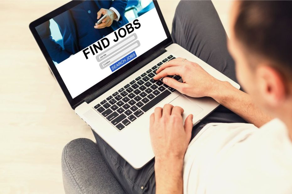 Seseorang sedang membuka laptop dengan tampilan layar "Find Jobs".