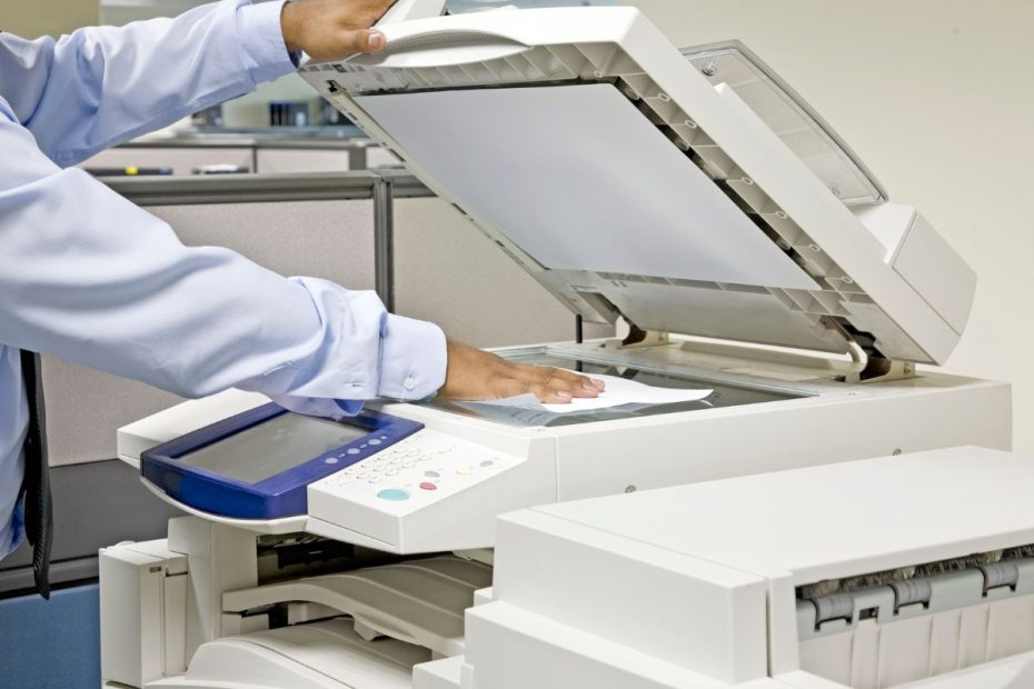 seseorang sedang menggunakan mesin fotocopy.