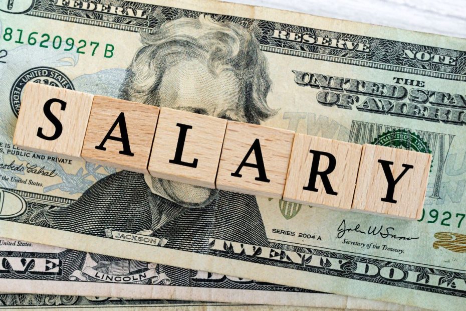 Tulisan "SALARY" di atas tumpukkan uang dollar.