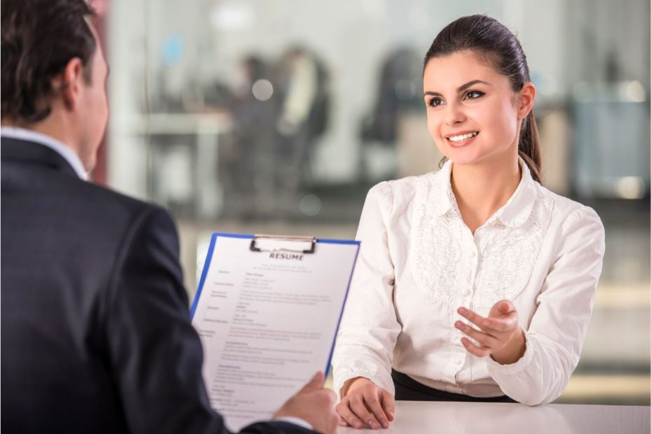 Seorang wanita sedang melakukan proses interview dengan tim rekruiter yang memegang CV.