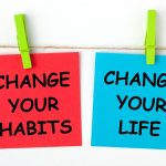 Sticky notes warna merah bertuliskan "CHANGE YOUR HABITS" dan warna biru bertuliskan "CHANGE YOUR LIFE".