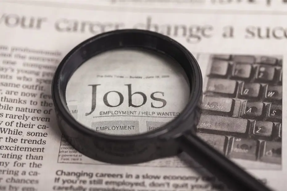 Kaca pembesar yang menunjukkan tulisan "Jobs" di koran.