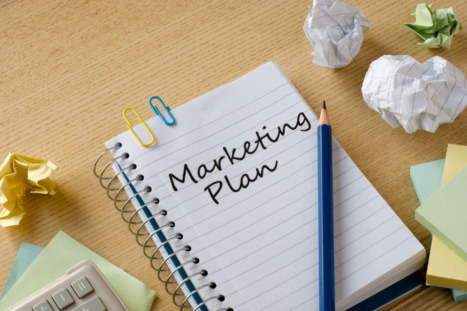 Tulisan "marketing plan" di buku catatan.