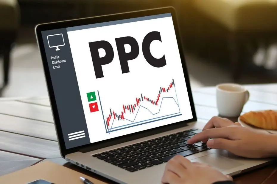 Tampilan layar laptop yang menunjukkan tulisan "PPC" (pay per click) dengan grafik di bawahnya.
